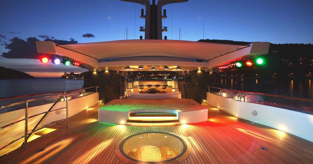 night shot of benetti superyacht st david's sun deck, with coloured lights creating dancefloor and private nightclub