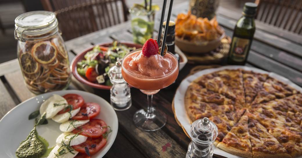 Table of food, including pizza, salad and frozen cocktails served at Diablito in Yas Marina, Abu Dhabi 