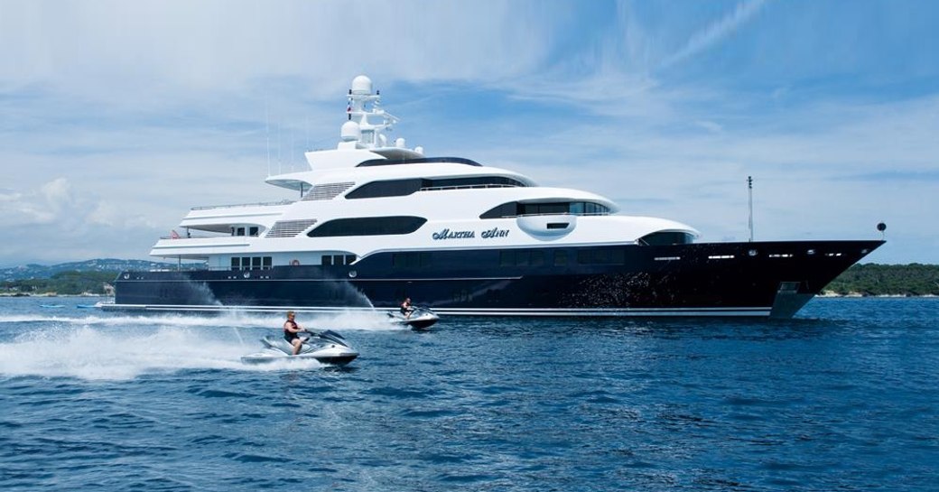 superyacht Martha Ann anchors on a yacht charter as jet skis take to the water