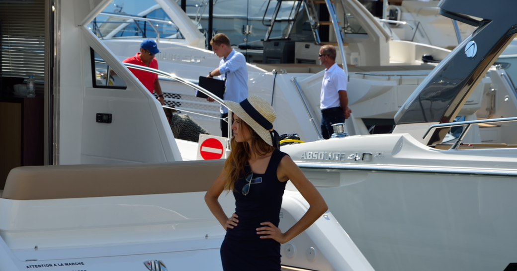 Woman stands on deck of yacht at cannes yachting festival