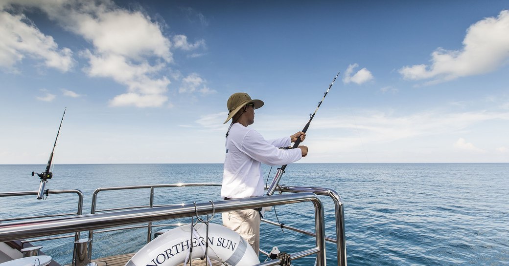 charter guest fishes off of superyacht ‘Northern Sun’ in South East Asia