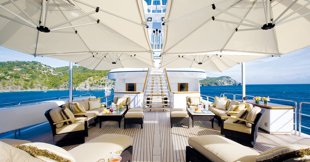 Sundeck on superyacht SOLO with alfresco seating areas and parasols