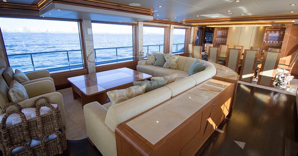 huge windows bathe L-shaped sofa in natural light in main salon aboard superyacht SERENITY