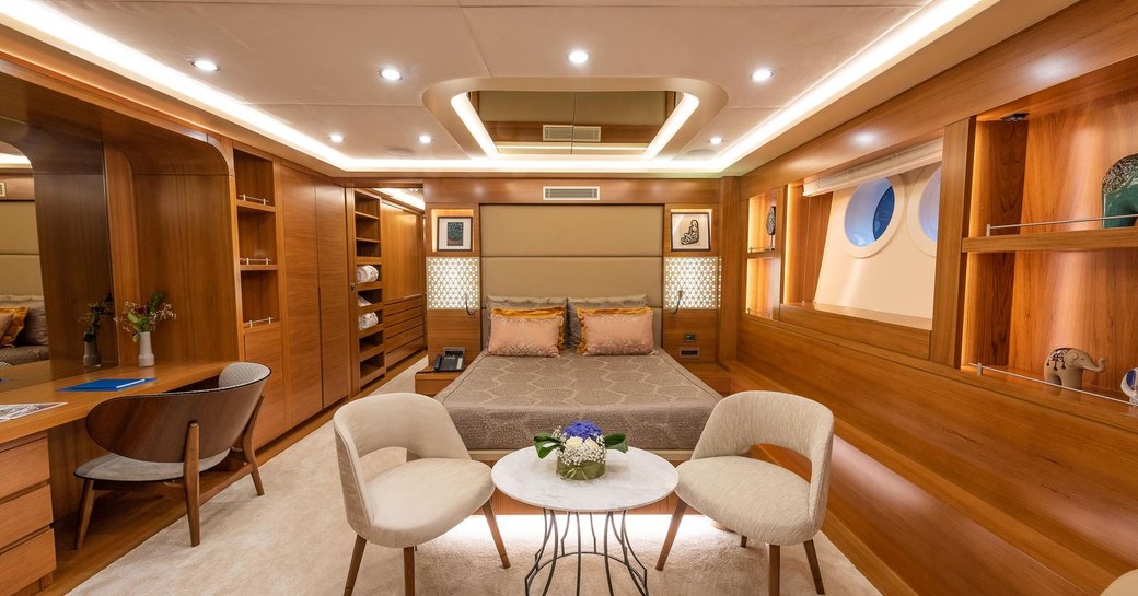 View of luxury cabin on sailing yacht ARESTEAS, with table at foot of bed and study area 