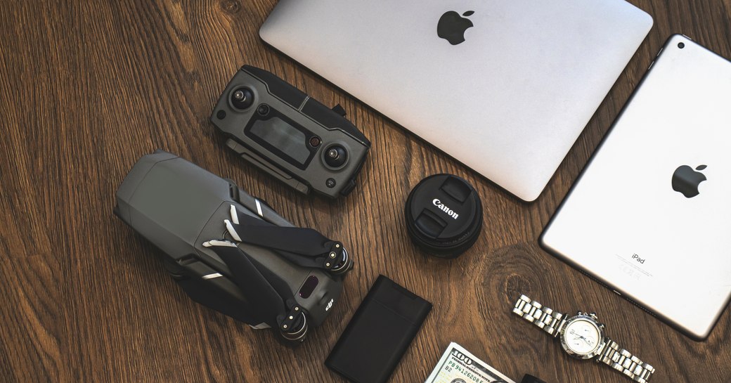 An array of tech gadgets lying on a wooden table