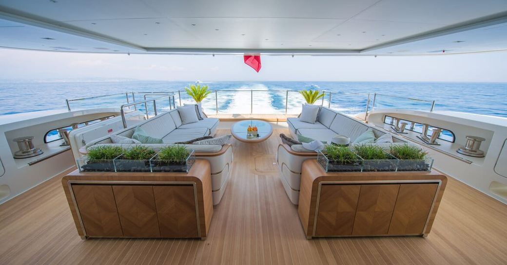 Overview of the aft deck onboard boat charter SCORPION with whit sofas and surrounding sea views
