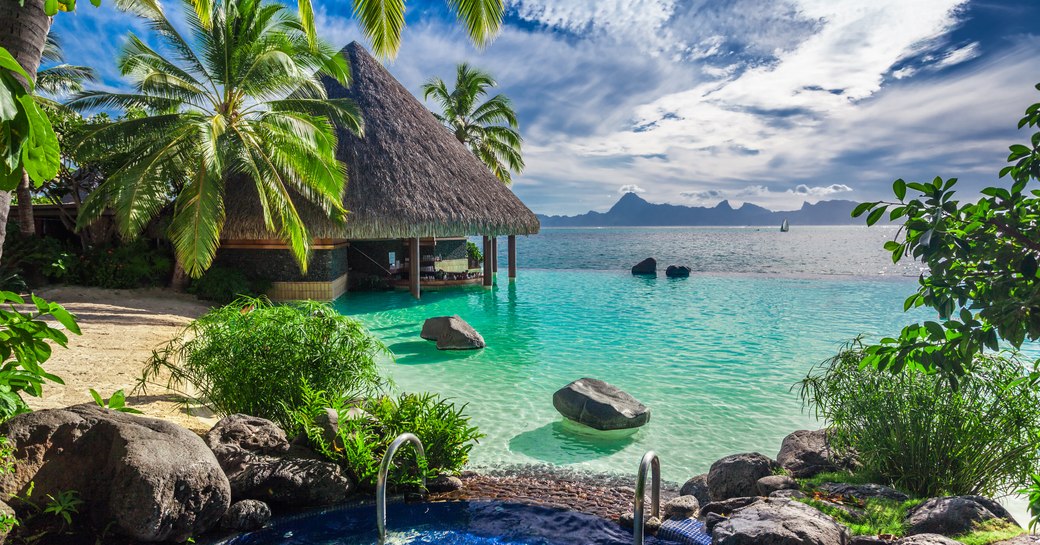 Thatched wooden over-water bungalows in Moorea