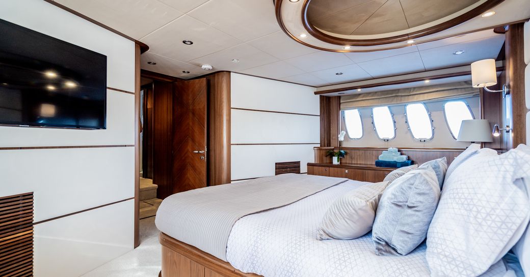 luxury yacht chess master suite with white carpets and wide windows 