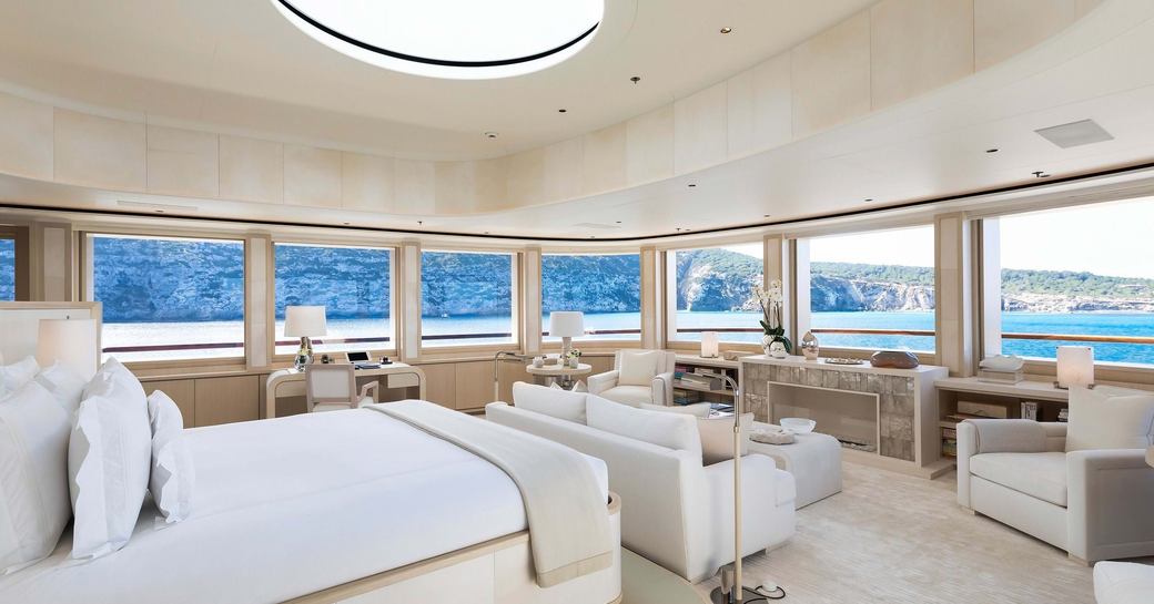 Master cabin with central berth surrounded by windows onboard superyacht charter SOPHIA