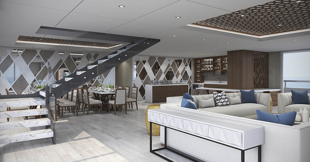 white sofas with bar and dining area beyond in the main salon aboard luxury yacht ELITE 