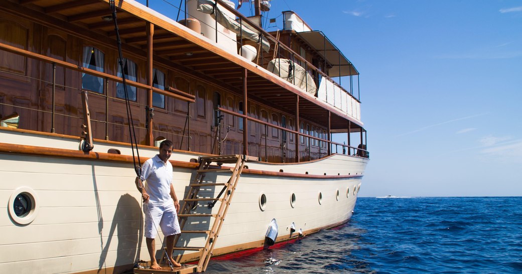 Superyacht over the rainbow crew member inviting guests on board 