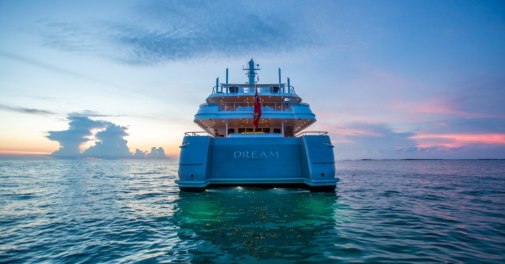 the stern of charter yacht Dream as the sun sets