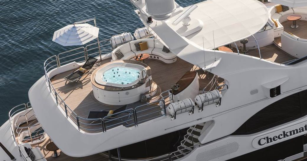 aerial view of the sundeck with a Jacuzzi, loungers and seating areas on board superyacht CHECKMATE 