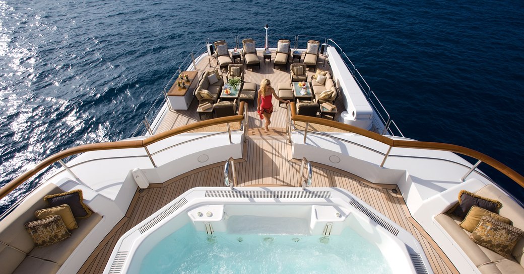 charter guest ascends stairs to the Jacuzzi on the top deck of luxury yacht UTOPIA