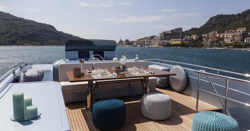 Table and comfortable seating on deck of superyacht 55 FIFTYFIVE