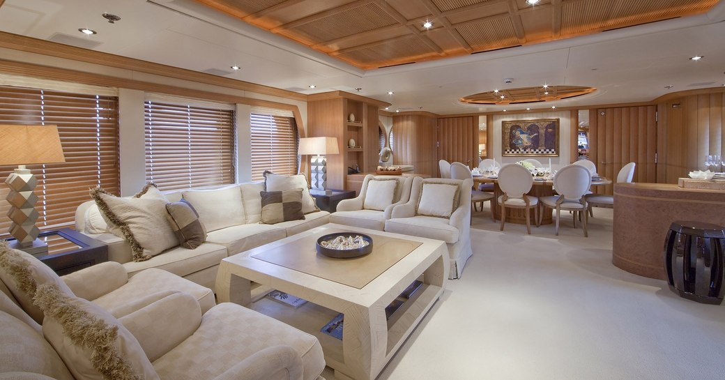 timeless main salon with sumptuous lounge and formal dining area on board charter yacht Deja Too