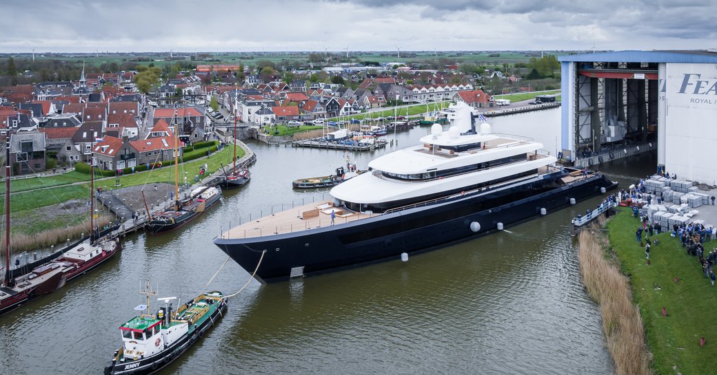 Overhead view of Feadship Project 1012 leaving the construction shed under tug escort