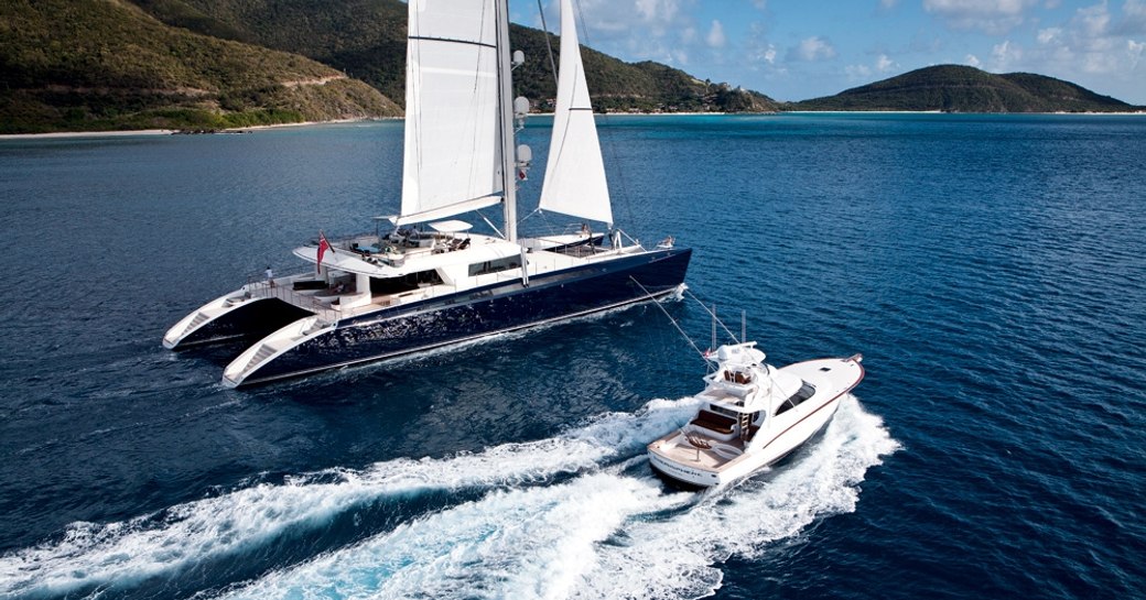 luxury catamaran HEMISPHERE docks in exotic cruising grounds as her tender zips past