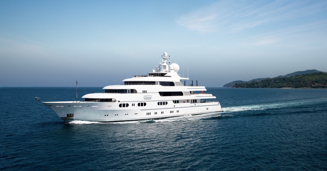 Superyacht TITANIA cruising beneath a cloudless sky