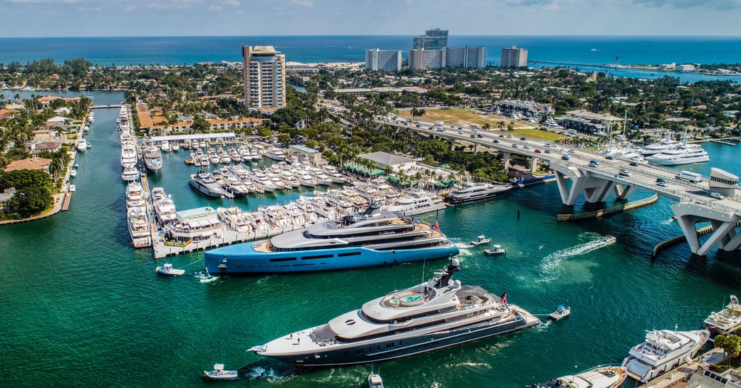 Two superyachts on the water at FLIBS 2019, passing below the bridge 