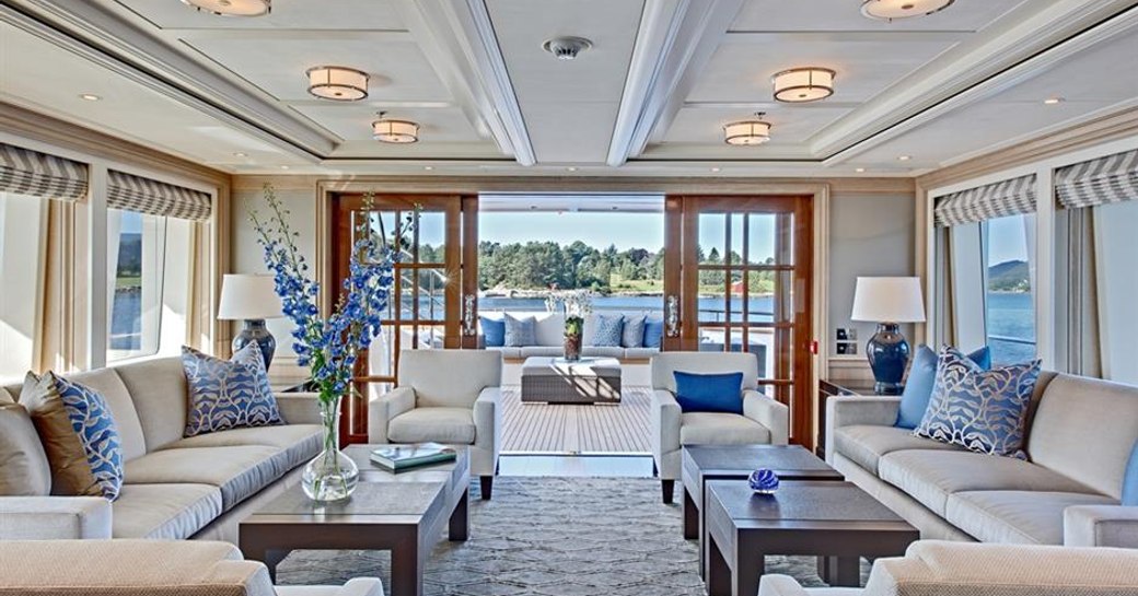the bright and airy main salon of charter yacht fabuous character with bright windows that open out to the main deck aft and blue accents that brighten the room