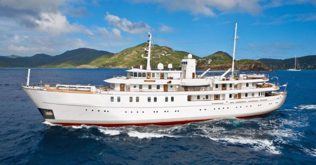 Superyacht SHERAKHAN cruising with a green island in the background