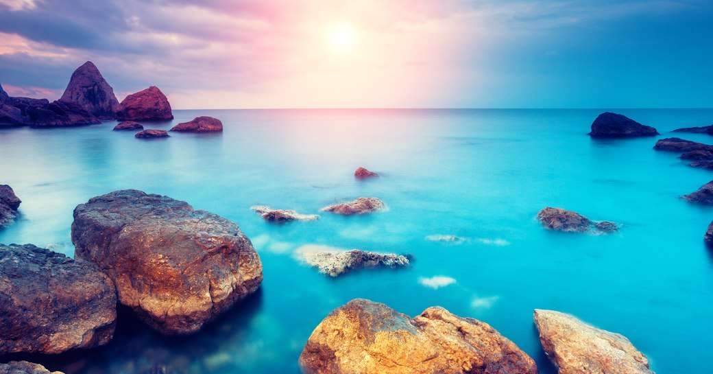 submerged rocks in a blue lagoon island at sunset in the maldives