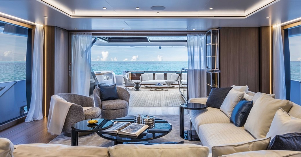 sumptuous seating area in the main salon of luxury yacht Vista Blue looking out onto aft deck