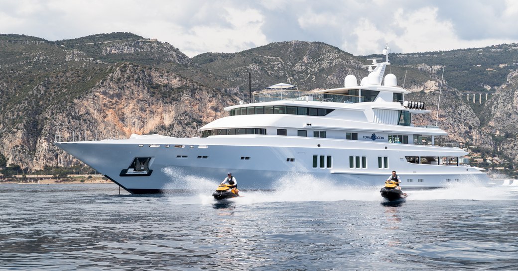 Charter yacht CORAL OCEAN underway with tall cliffs in the background