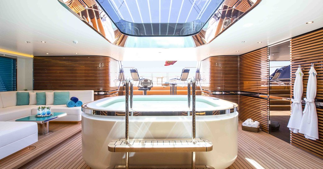 beach club of sailing yacht aquijo, with jacuzzi below glass ceiling panels and access to swim platform in background