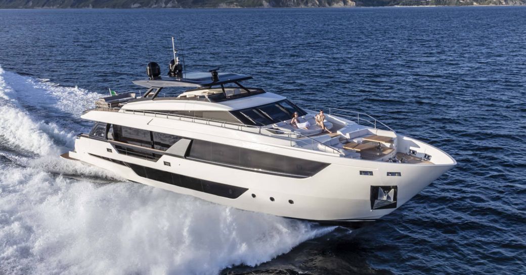 Charter yacht ISOTTA underway, surrounded by sea with cliffs in the background