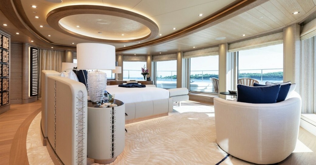 Overview of the master cabin onboard charter yacht STARBURST IV, central berth facing forward with armchair and surrounding windows