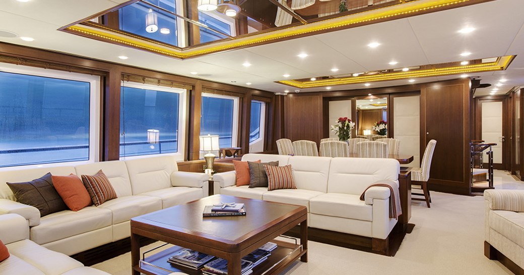 sociable lounge with dining table beyond in main salon of motor yacht Masteka 2