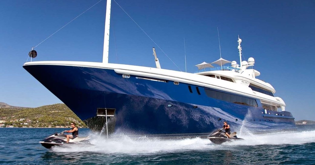 luxury yacht Mary-Jean II anchors on a Caribbean yacht charter while jet skis take to the waters