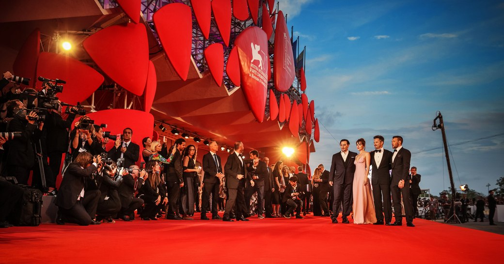 movie stars have their picture taken on the red carpet at the venice film festival