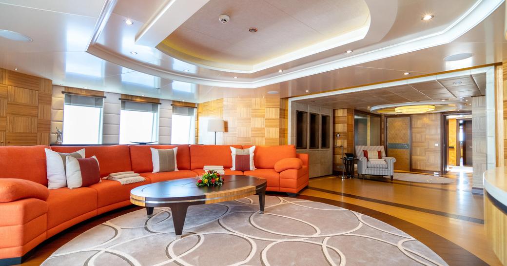 Interior lounge area with orange sofa onboard charter yacht KAISER