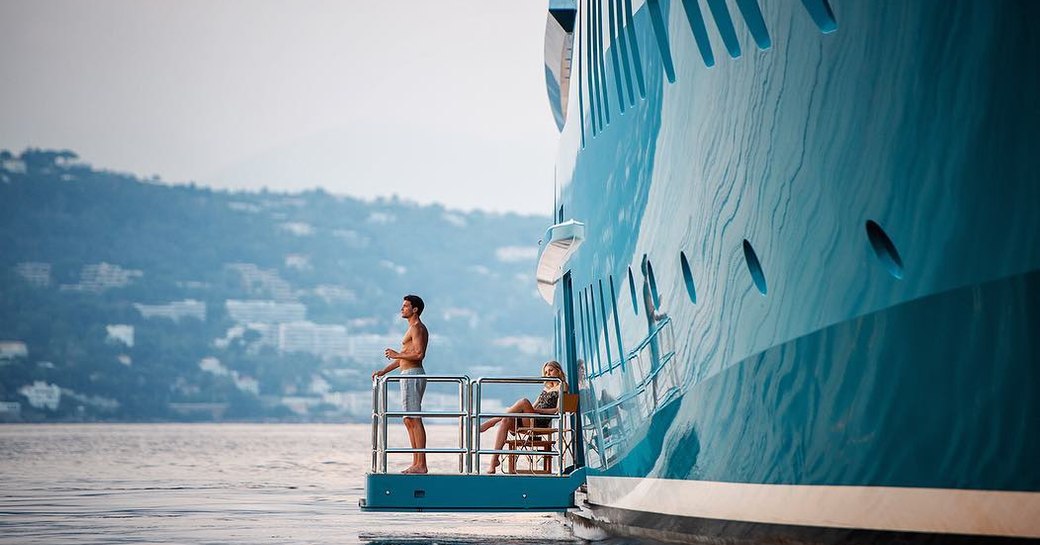 Couple on fold down balcony of Superyacht SUNRAYS looking out to sea