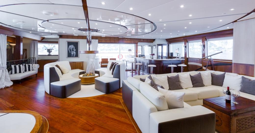 Charter yacht AQUA LARES interior lounge area with plush white seating