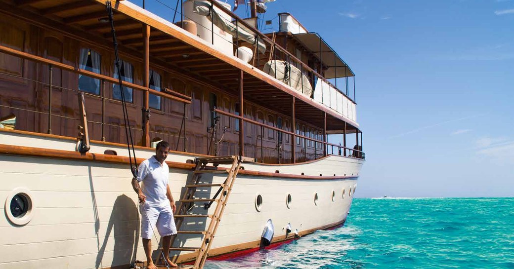 crew greets guests stepping on board luxury motor yacht over the rainbow