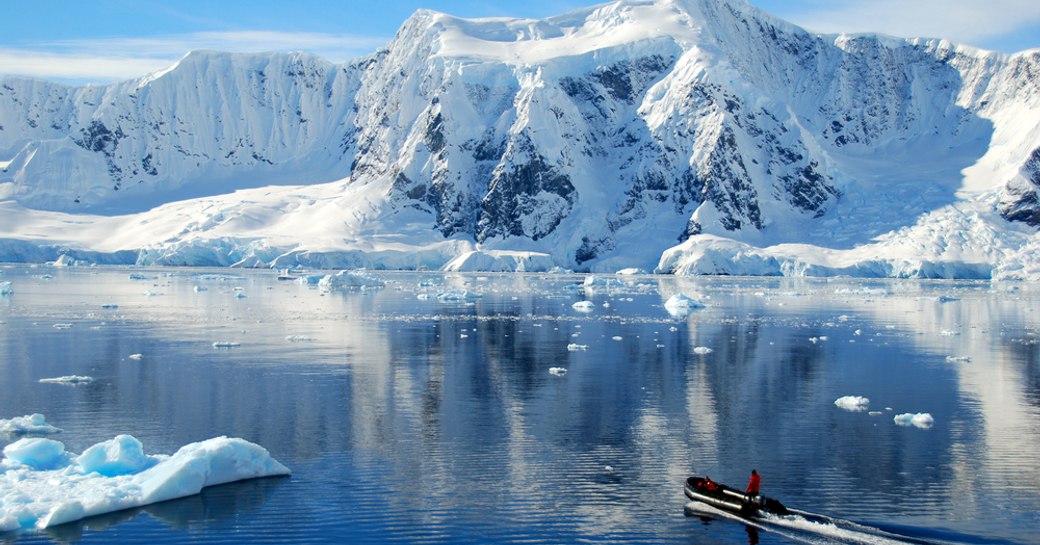 RIB tender explores the calm waters and dramatic snowy landscapes of Antarctica