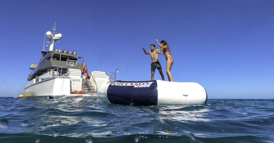 Two charter guests on an inflatable behind superyacht MIZU