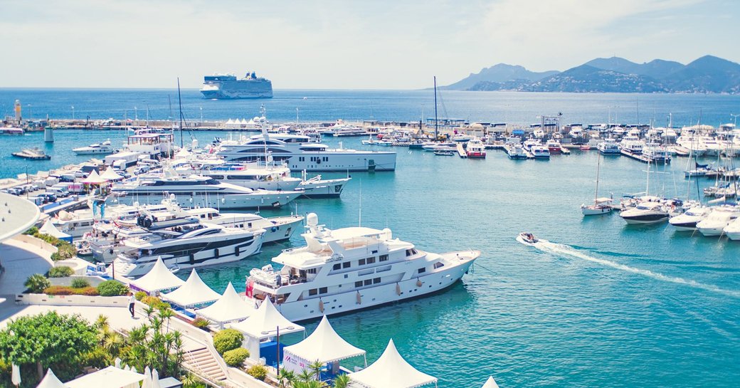 a fleet of superyachts in cannes getting ready to wow and impress many business people making deals