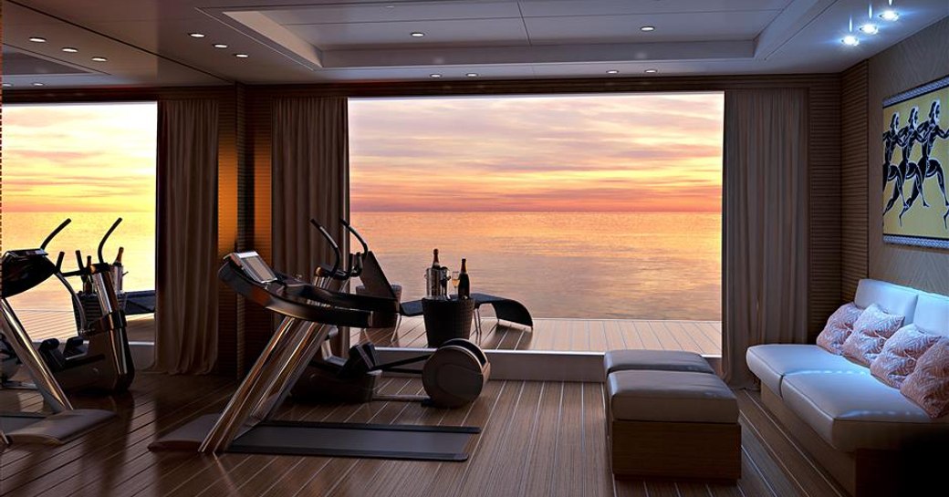 superyacht spectre beach club from inside, looking out over sunset on the water. gym equipment lined up and comfortable seating, with drinks on table outside