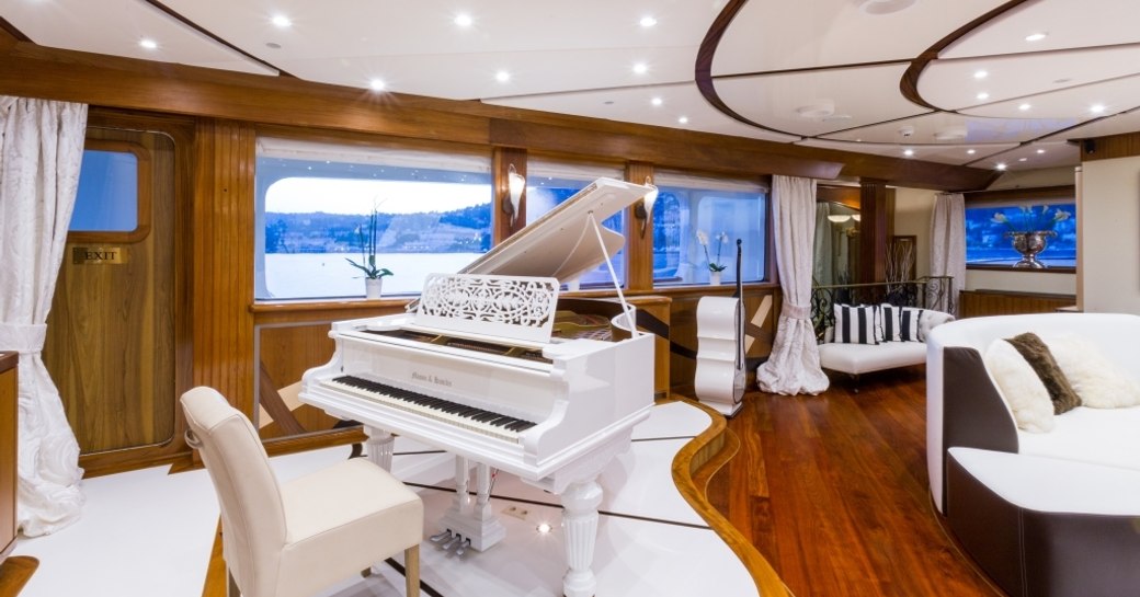 white piano in the main salon alongside sumptuous seating areas on board expedition yacht LEGEND