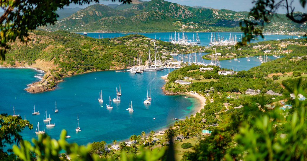 Overview of Nelson's Dockyard with multiple sailing yacht charters at anchor