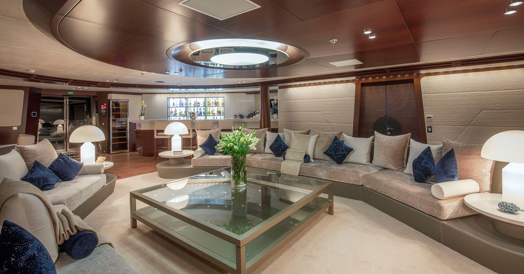 Interior lounge area onboard charter yacht KATINA with large sofas and scatter cushions