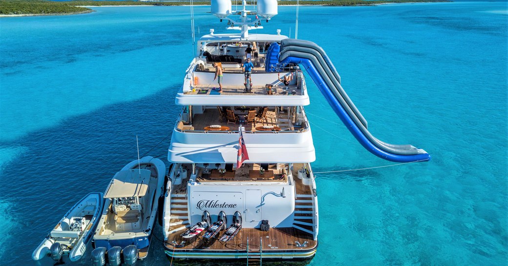 Superyacht Milestone at anchor in the Caribbean, with water slide going into the sea