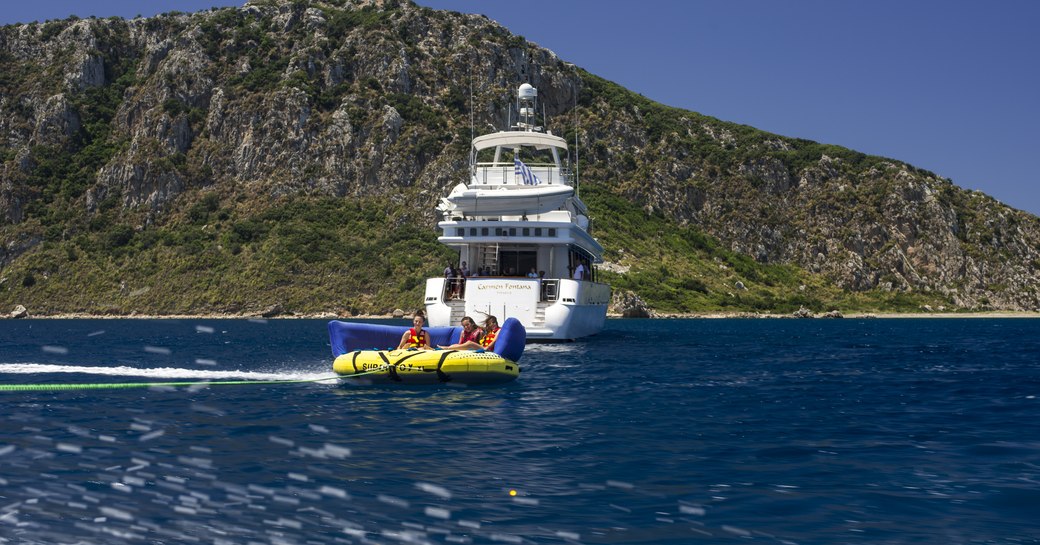 guests riding an inflatable raft being chauffeured by crewed yacht carmen fontana's speed boat