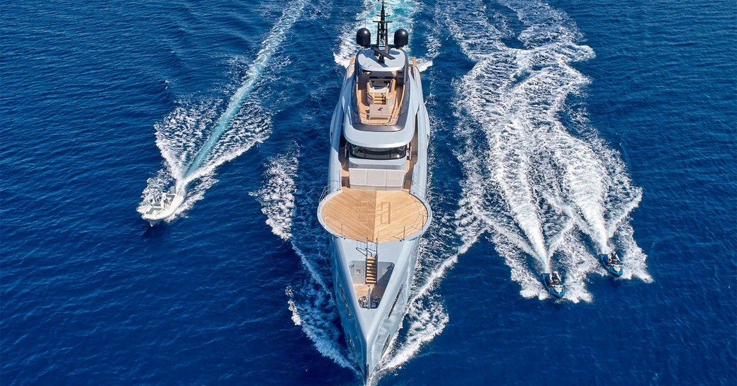 superyacht geco while underway, foredeck helipad and tenders alongside