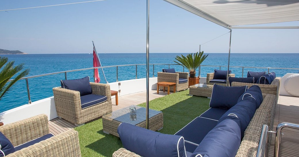 Aft seating space with grass section aboard charter yacht MIRAGGIO